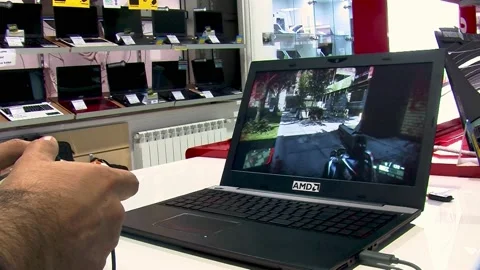Man in a store is playing video game on laptop Stock Footage 220560402
