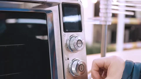 The man in the store selects the oven. Check the operation of the device. When Stock Footage 150075582