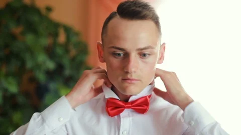 Man straightens bow-tie close up. Success style confidence establishment Stock Footage 95757597