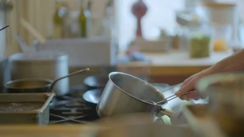 Man straining water with strainer from cooking pan in kitchen Stock Footage 87804848