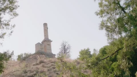 A man in a straw hat with a rare camera walks past an ancient stone plinth Stock Footage 245481674