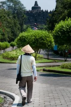 Man with straw hat walking towards Borobudur temple Stock Photos
