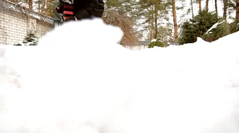 Man on the street cleans snow red spade Stock Footage 61173789