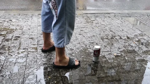 A man on the street pulls out his pants and lifts a can of beer off the sidewalk Video stock 157219147