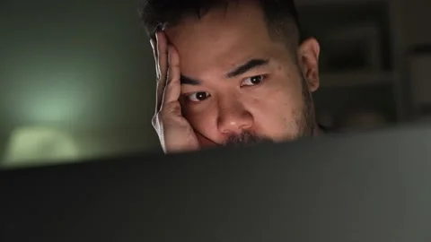 Man stressed and tired while using computer working late at night at home. Stock Footage 167941911