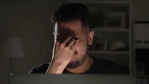 Man stressed and tired while using computer working late at night at home. Stock Footage 167941923