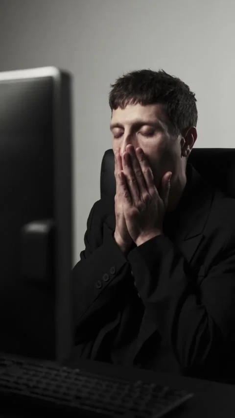 Man stressed at computer desk feeling overworked and exhausted in dark office Stock Footage 318020179