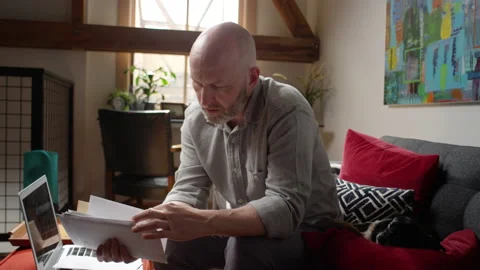 Man stressed out on how he is going to pay his bills throws a stack of envelopes Video stock 133291458