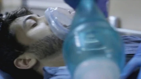 Man on stretcher with oxygen mask being rushed to ER Stock Footage
