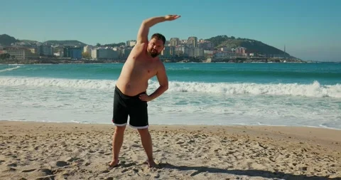 A man stretches on the beach before a workout. Stock Footage 171527659