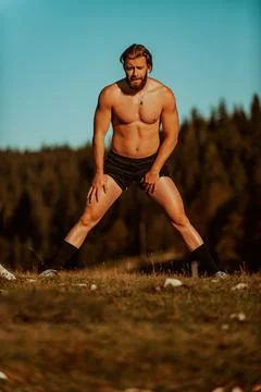 A man stretching after a hard workout in the early hours of the morning Stock Photos