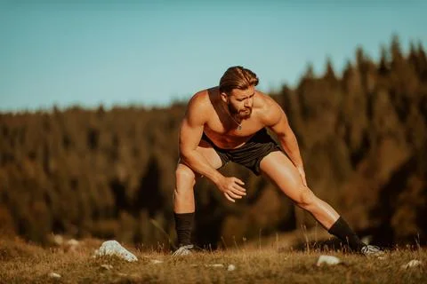 A man stretching after a hard workout in the early hours of the morning Stock Photos