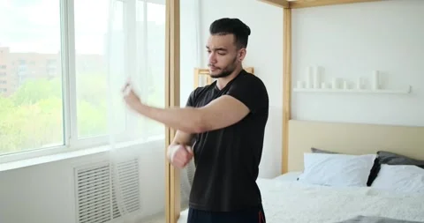Man stretching and warming up for workout in bedroom Stock Footage 156521437