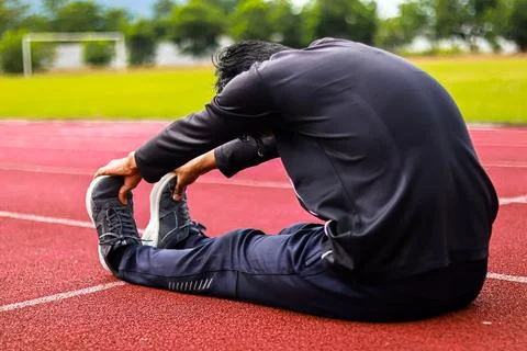 Man stretching on athletic track, preparing for sport, fitness and healthy .. Stock Photos