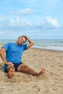 Man Stretching on Beach with Ocean View Stock Photos