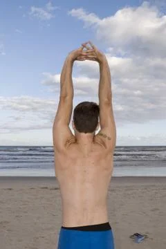 Man stretching in the beach Stock Photos