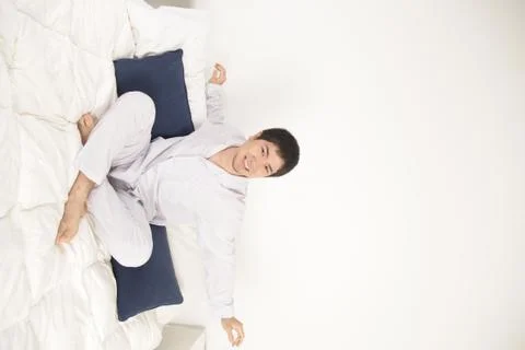 Man stretching on the bed Stock Photos
