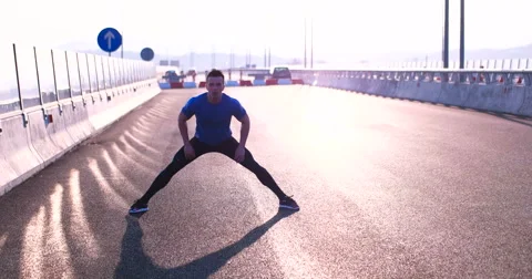 Man stretching on the bridge on a sunset Stock Footage 67235359