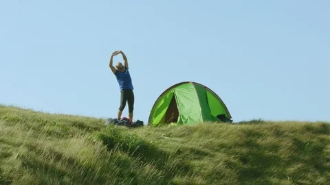 Man Stretching In Front Of His Tent After A Night Spent In The Wild Stock Footage 93661548