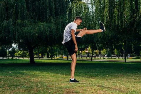 Man stretching hamstring leg muscles during outdoor crossfit workout Stock Photos