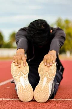 Man Stretching Hamstrings on Running Track Stock Photos