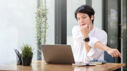 Man stretching her arms while relaxing at her workplace. Stock Photos