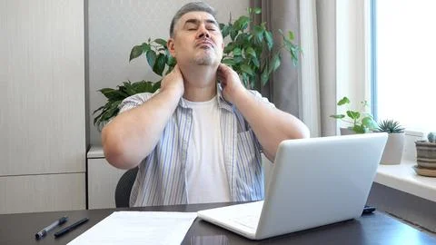 Man Stretching Neck While Working on Computer Stock Photos
