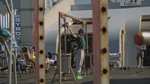 Man Stretching on outdoor gym pull up bar Stock Footage 255342273