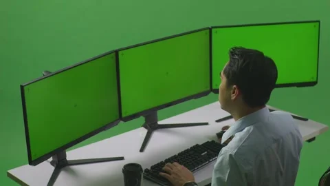 Man Stretching While Working With Mock Up Multiple Computer Monitor In Green Stock Footage 249634749