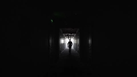 The man strides confidently forward along the dark corridor. Stock Footage 139191448