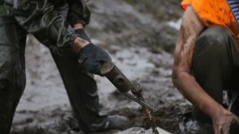 Man strike big nail with hammer in slow motion. Try to get stucked car from mud Stock Footage 77429515