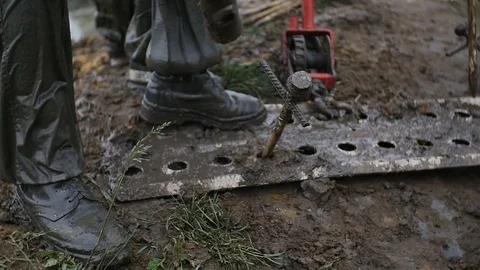 Man strike big nail with hammer, while worker uses track jack in slow motion Stock Footage 77429614