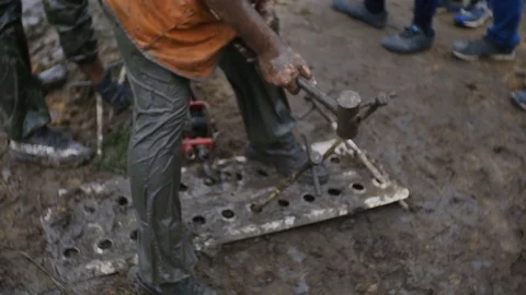 Man strike big nail with hammer, while worker uses track jack in slow motion Video stock 77429730