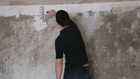 Man strikes the primer on the plaster wall Stock Footage 83873070