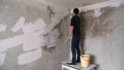 Man strikes the primer on the plaster wall Stock Footage 83873164