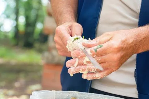 Man stringing marinated meat on skewer for barbecue Stock Photos