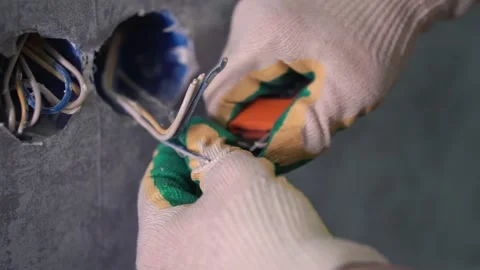 The man strips the wires to install the socket. Stockbeeldmateriaal 147077302