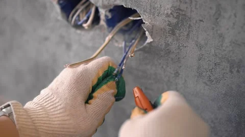 The man strips the wires to install the socket Stockbeeldmateriaal 147077324