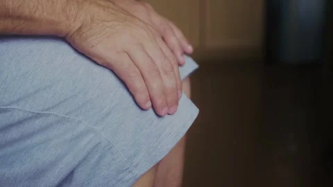 A man strokes his knee Stock Footage 317433799