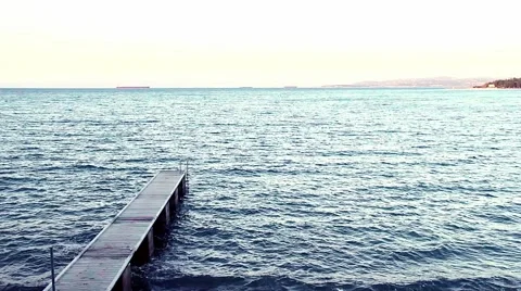 Man strolling along the pier and the waves lapping on the pier in the Adriatic. Video stock 68963793