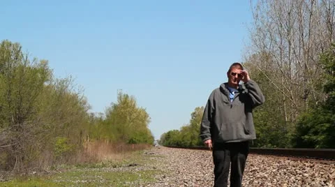 Man strolling along rail road tracks 動画素材 10873996
