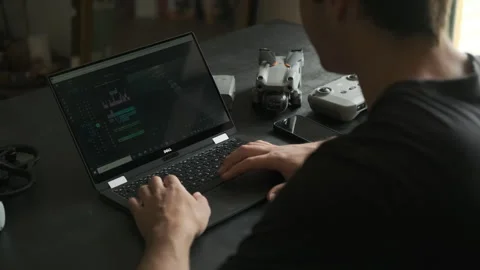 Man struggles to edit a video in a room. Drones on the table. Stock Footage 243424113