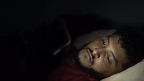 Man struggling with sleeplessness using smartphone in bed at night Stock Footage 301088058