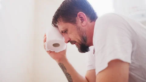 Man struggling on toilet in bathroom while experiencing digestive discomfor.. Stock Footage 342761069