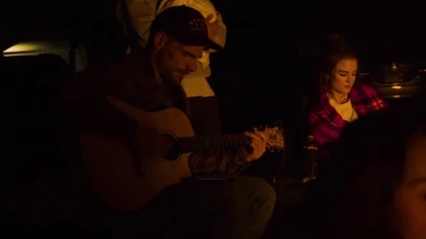 Man Strumming Guitar by the Bonfire Stock Footage 271296527
