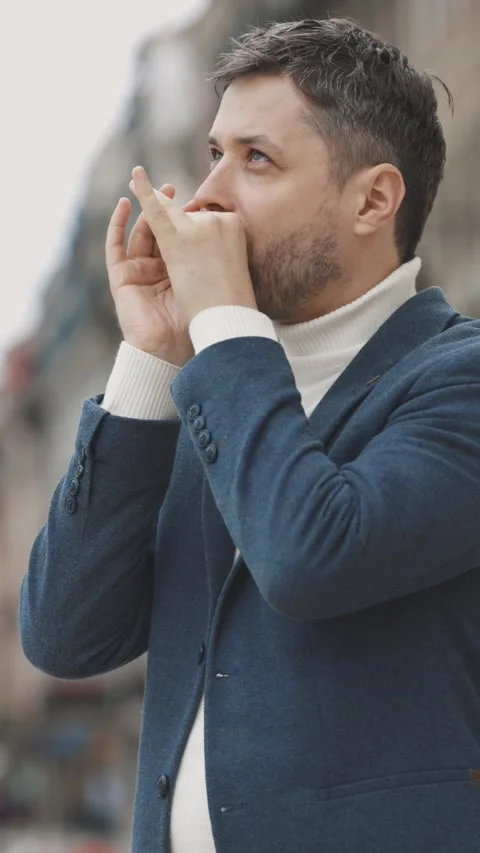 Man with stubble playing harmonica on the street Stock Footage 328343245