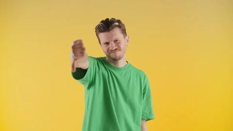 A man with stubble stands in front of the camera and gives a thumbs down. The Stock Footage 240471801