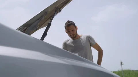 Man stuck with broken car - looking inside the trunk in disappointment Stock Footage 107543925