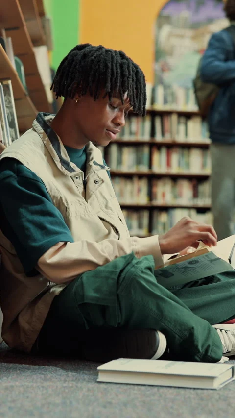 Man, student and reading in library with textbook for learning, education or Stock Footage 335808054