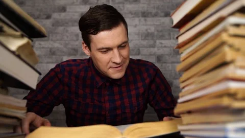 Man student boring reading book at library with a lot of books in university Stock Footage 109484918